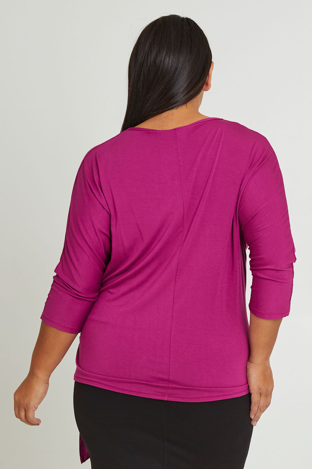 Model Ashleigh wearing size 16 of The Bamboo Tie Waist Top in colour Berry (Pink), from the back