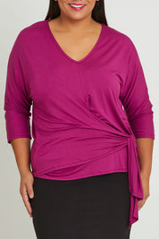 Model Ashleigh wearing size 16 of The Bamboo Tie Waist Top in colour Berry (Pink), from the front, cropped image