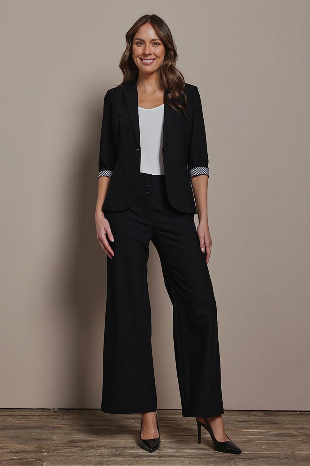 Model Madeline wearing size 10 of The Tailored Pant in colour Black (Black), from the front, showing the whole outfit