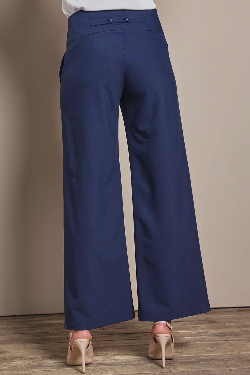 Model Madeline wearing size 10 of The Tailored Pant in colour Navy (Blue), from the back