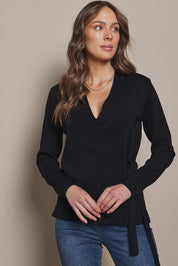 Model Madeline wearing size S of The Milano Knit Wrap Top in colour Black (Black), from the front, cropped image
