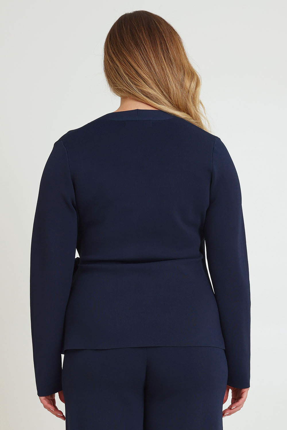 Model Chanel wearing size XL of The Milano Knit Wrap Top in colour Darknavy (Blue), from the back