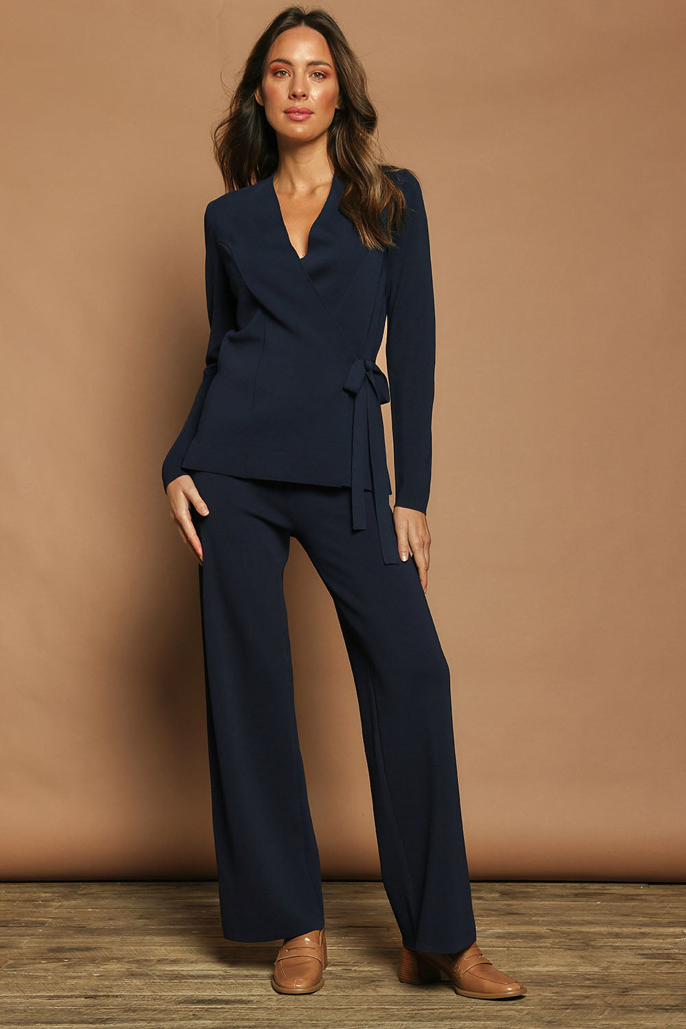 Model Madeline wearing size S of The Milano Knit Wrap Top in colour Darknavy (Blue), from the front, showing the whole outfit