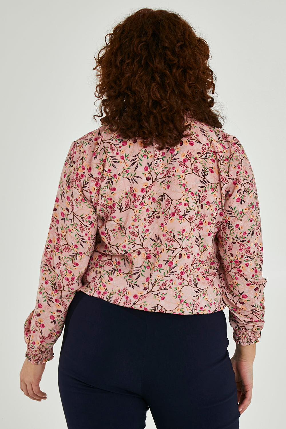Model Maddy wearing size 16 of The Shirring Detail Printed Blouse in colour Blossom (Pink), from the back