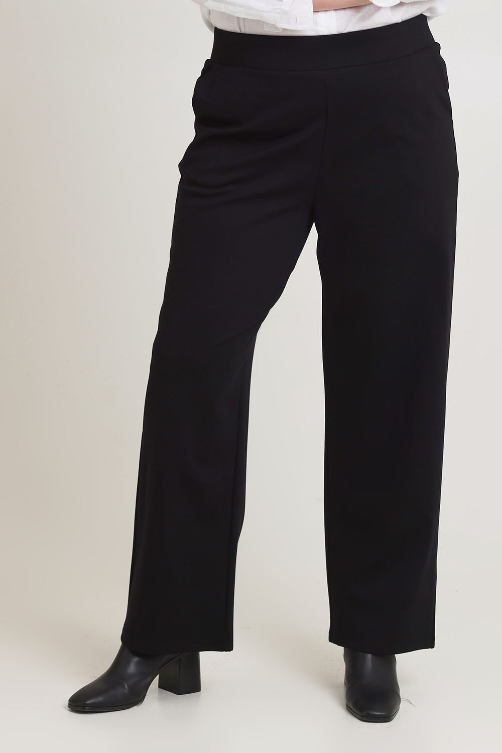 Model Chanel wearing size 16 of The Straight Cut Pull On Ponte Pant in colour Black (Black), from the front, cropped image