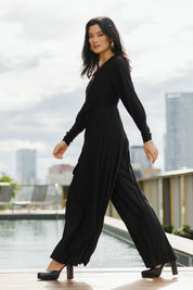 Model Miranda wearing size 10 of The Pleated Wide Leg Jumpsuit in colour Black (Black), from the front, showing the whole outfit
