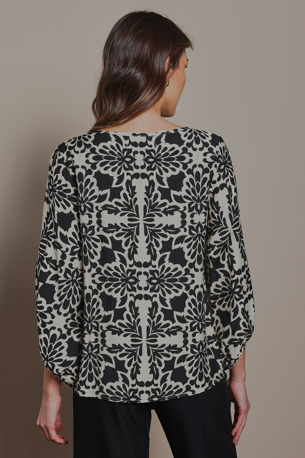 Model Madeline wearing size 10 of The Printed Bishop Sleeve Blouse in colour Black (Black), from the back