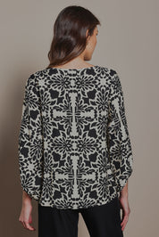 Model Madeline wearing size 10 of The Printed Bishop Sleeve Blouse in colour Black (Black), from the back