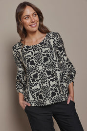 Model Madeline wearing size 10 of The Printed Bishop Sleeve Blouse in colour Black (Black), from the front, cropped image