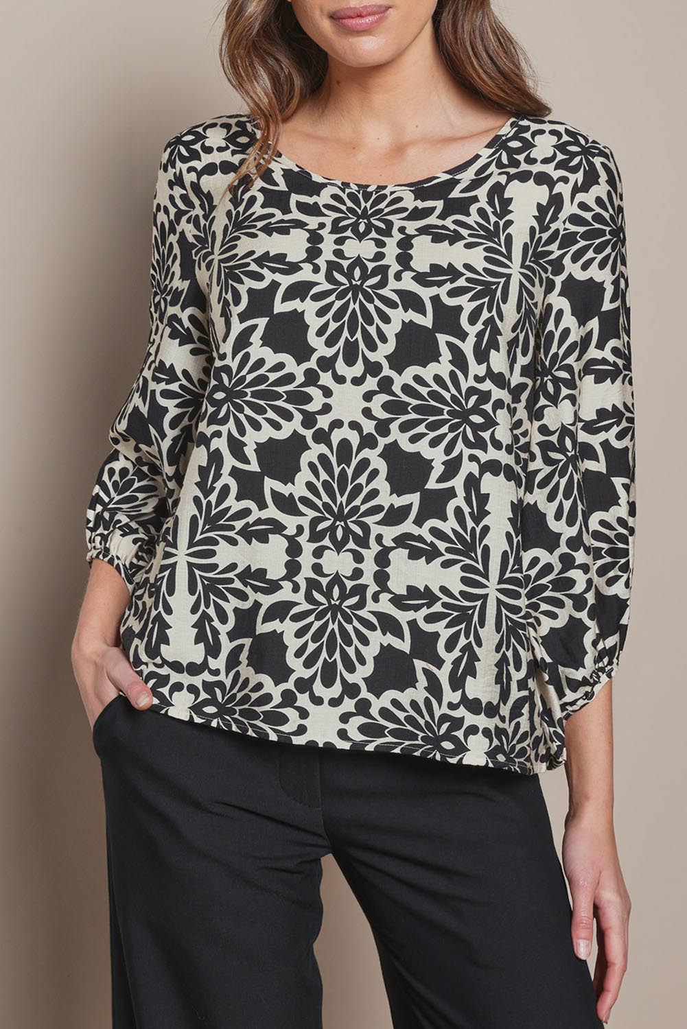Model Madeline wearing size 10 of The Printed Bishop Sleeve Blouse in colour Black (Black), from the front, cropped image
