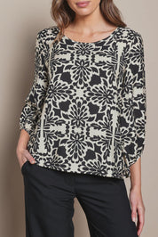 Model Madeline wearing size 10 of The Printed Bishop Sleeve Blouse in colour Black (Black), from the front, cropped image