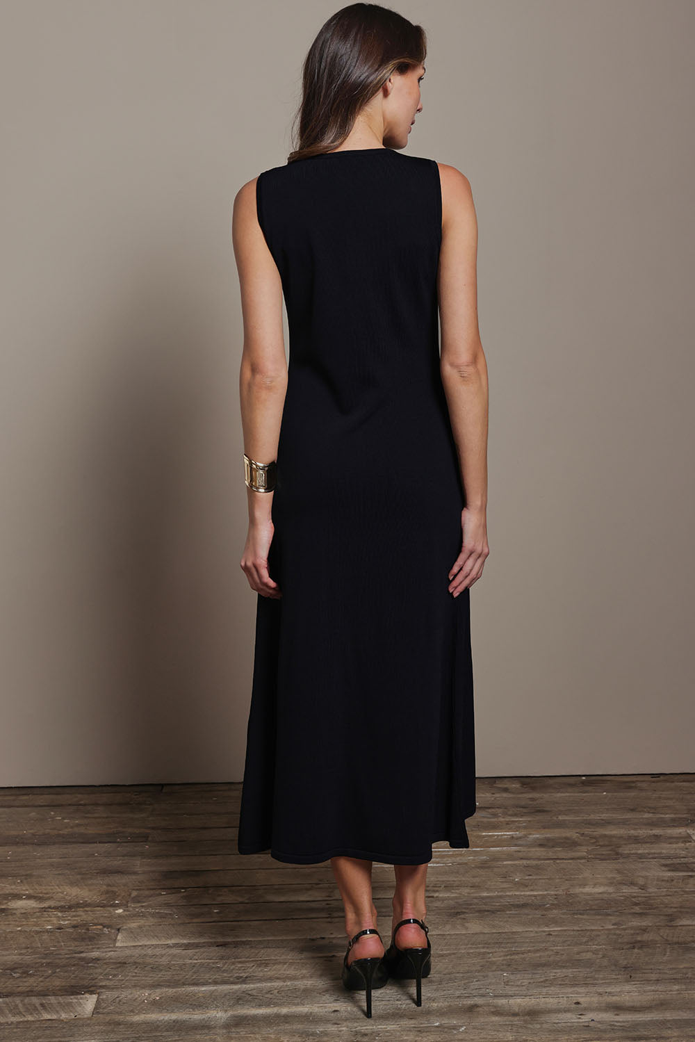 Model Madeline wearing size S of The Crepe Knit Button Detail Dress in colour Black (Black), from the back