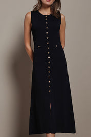 Model Madeline wearing size S of The Crepe Knit Button Detail Dress in colour Black (Black), from the front, cropped image