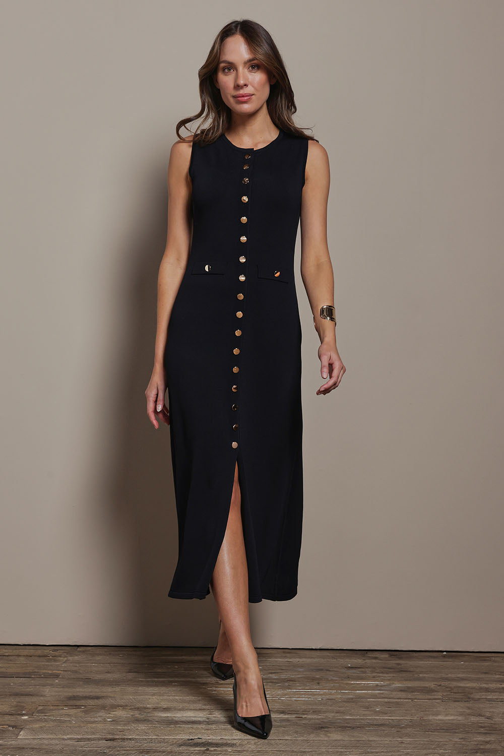 Model Madeline wearing size S of The Crepe Knit Button Detail Dress in colour Black (Black), from the front, showing the whole outfit
