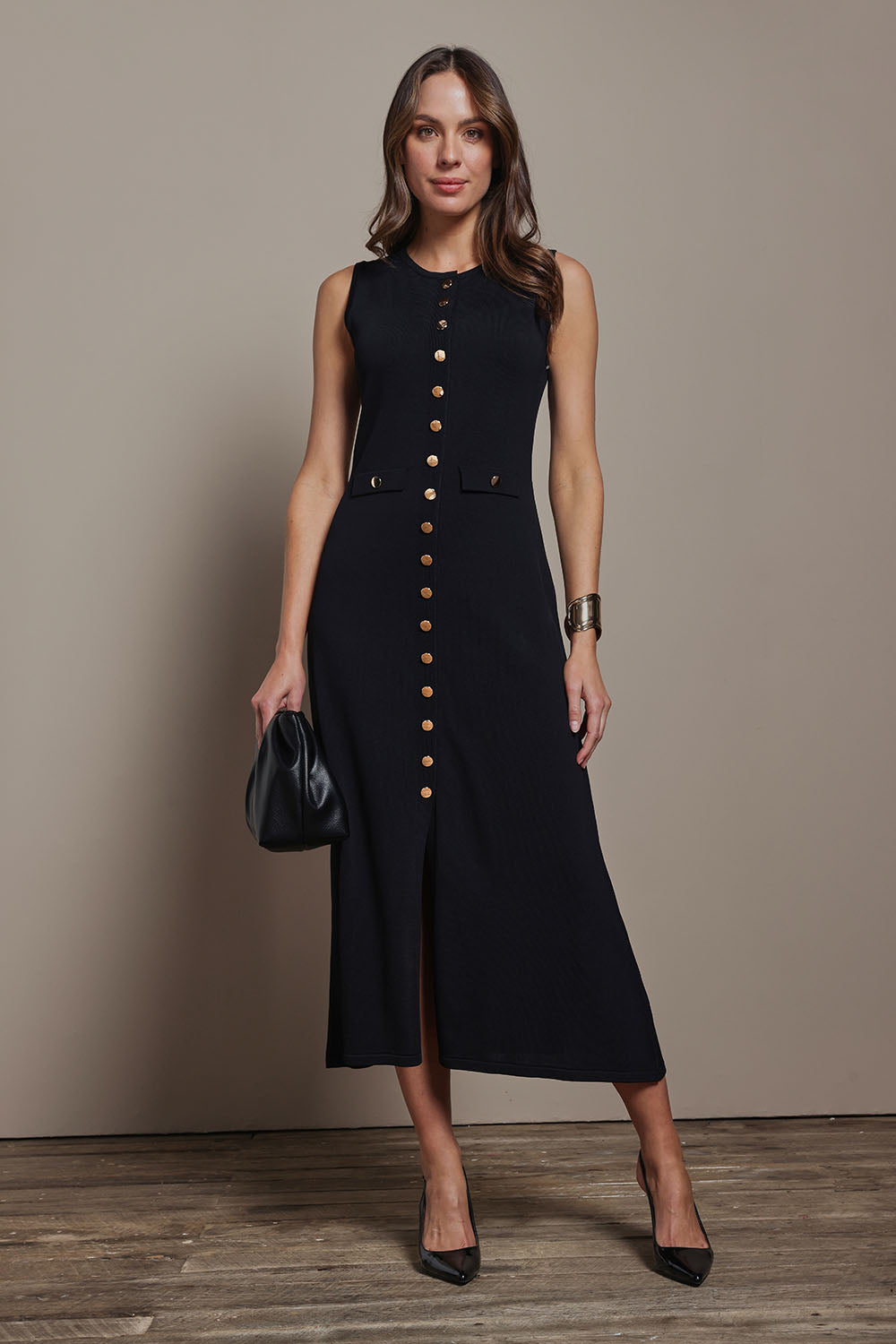 Model Madeline wearing size S of The Crepe Knit Button Detail Dress in colour Black (Black), from the front, showing the whole outfit