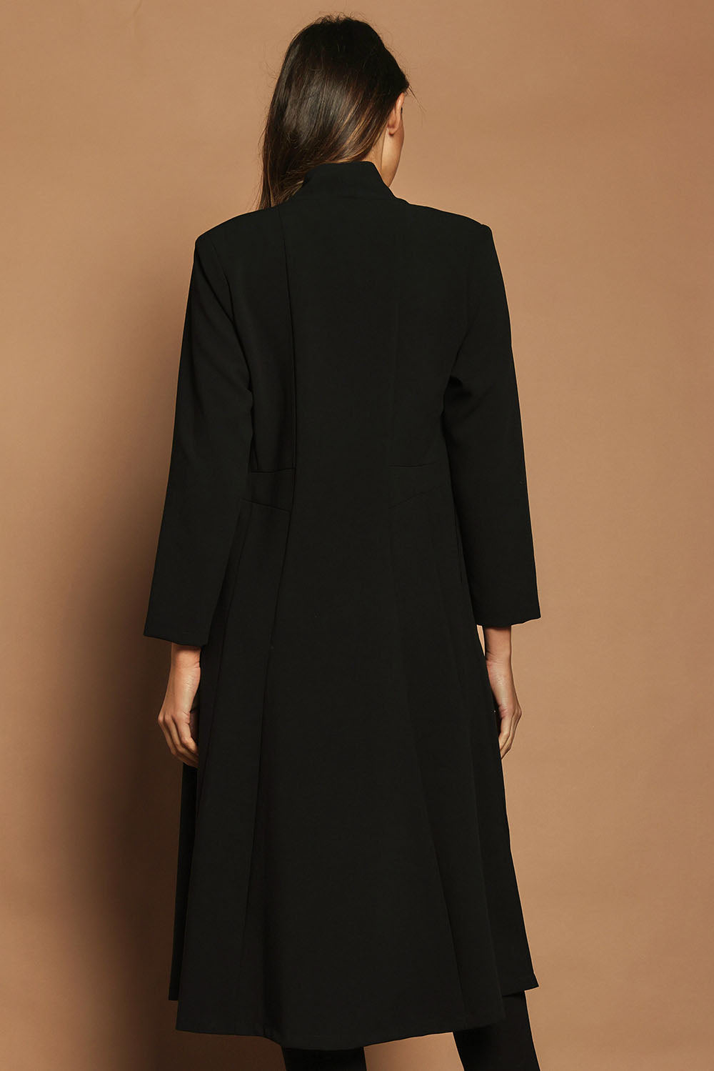 Model Madeline wearing size 10 of The Longline Coatigan in colour Black (Black), from the back