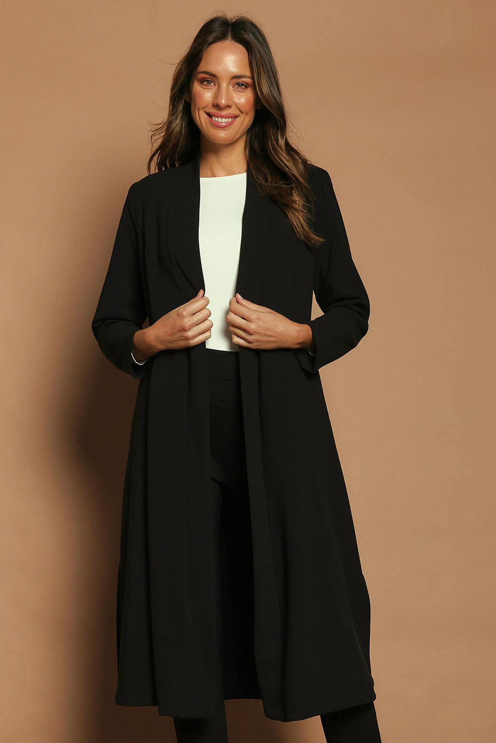 Model Madeline wearing size 10 of The Longline Coatigan in colour Black (Black), from the front, cropped image