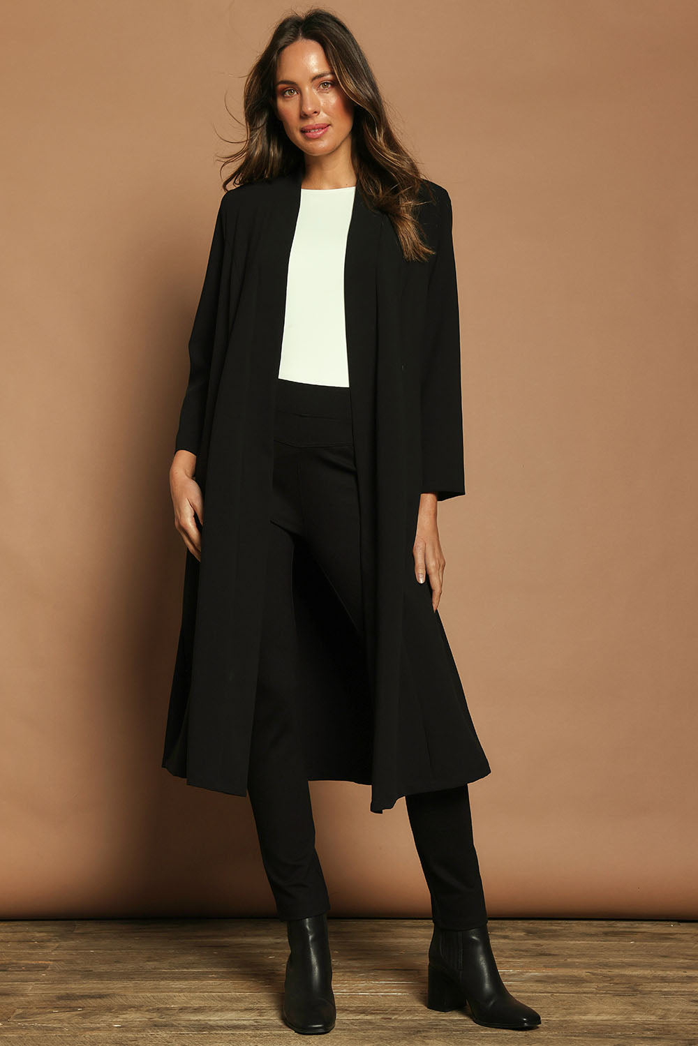 Model Madeline wearing size 10 of The Longline Coatigan in colour Black (Black), from the front, showing the whole outfit