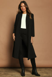 Model Madeline wearing size 10 of The Longline Coatigan in colour Black (Black), from the front, showing the whole outfit