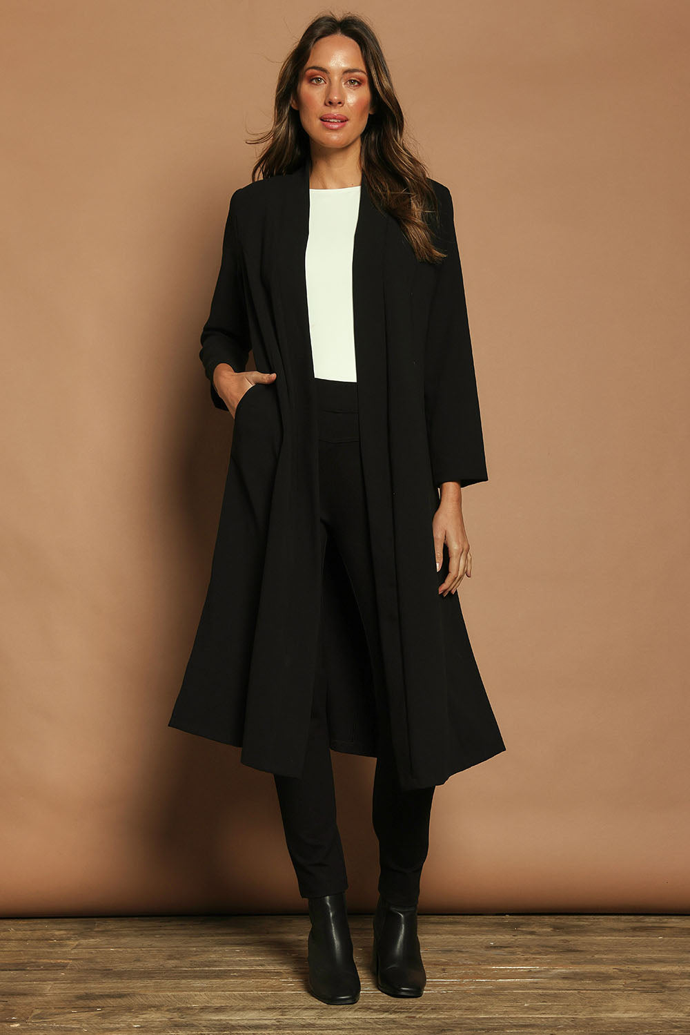 Model Madeline wearing size 10 of The Longline Coatigan in colour Black (Black), from the front, showing the whole outfit