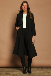 Model Madeline wearing size 10 of The Longline Coatigan in colour Black (Black), from the front, showing the whole outfit