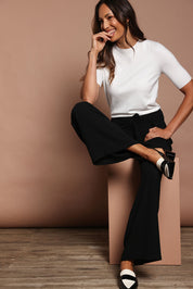 Model Amanda wearing size S of The Seamless Soft Crew Neck Knit in colour Snow (White), from the front, showing the whole outfit