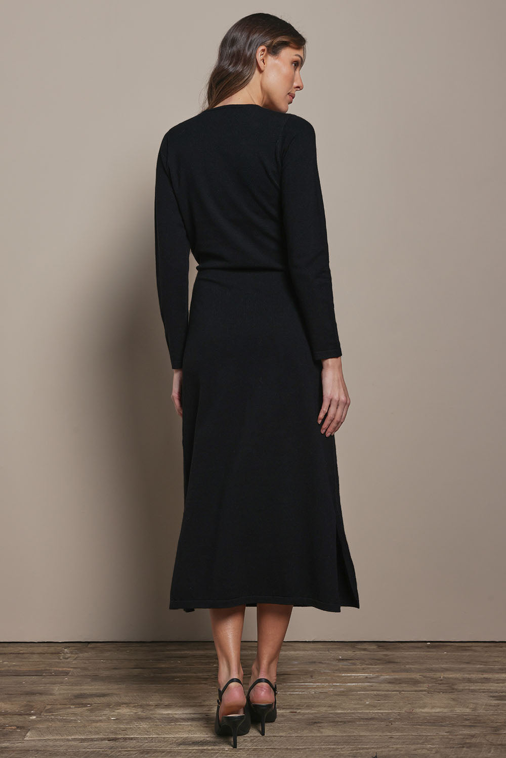 Model Madeline wearing size S of The Tie Waist Faux Wrap Knit Dress in colour Black (Black), from the back