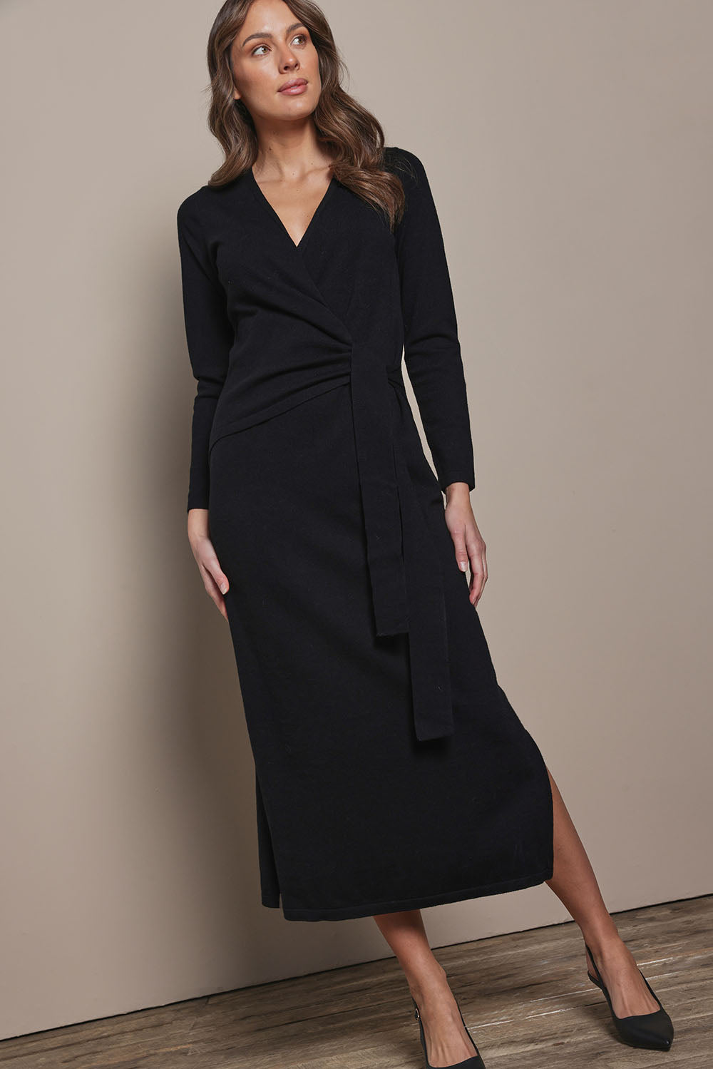 Model Madeline wearing size S of The Tie Waist Faux Wrap Knit Dress in colour Black (Black), from the front, showing the whole outfit