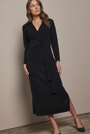 Model Madeline wearing size S of The Tie Waist Faux Wrap Knit Dress in colour Black (Black), from the front, showing the whole outfit