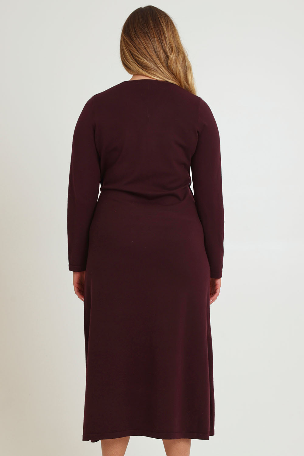 Model Chanel wearing size XL of The Tie Waist Faux Wrap Knit Dress in colour Burntplum (Purple), from the back