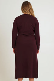 Model Chanel wearing size XL of The Tie Waist Faux Wrap Knit Dress in colour Burntplum (Purple), from the back