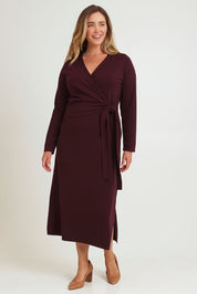 Model Chanel wearing size XL of The Tie Waist Faux Wrap Knit Dress in colour Burntplum (Purple), from the front, showing the whole outfit