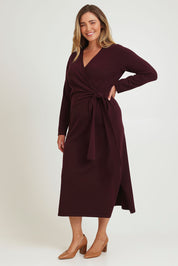 Model Chanel wearing size XL of The Tie Waist Faux Wrap Knit Dress in colour Burntplum (Purple), from the front, showing the whole outfit