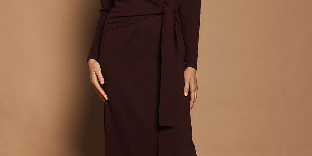 Model Madeline wearing size S of The Tie Waist Faux Wrap Knit Dress in colour Burntplum (Purple), from the front, showing the whole outfit
