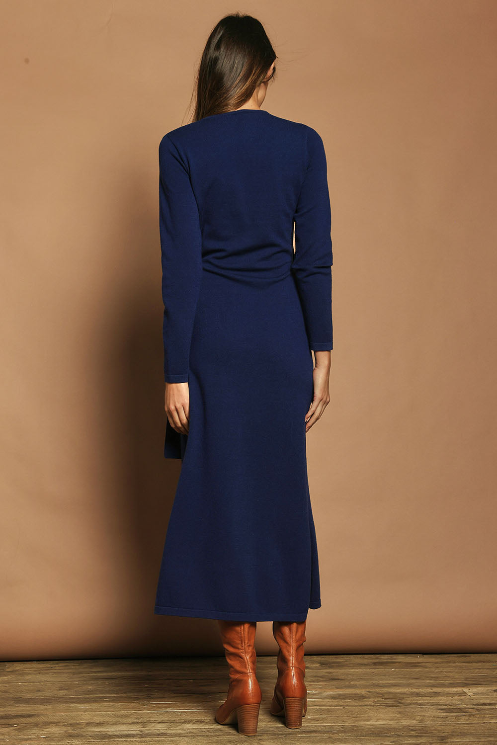 Model Madeline wearing size S of The Tie Waist Faux Wrap Knit Dress in colour Navyblue (Blue), from the back