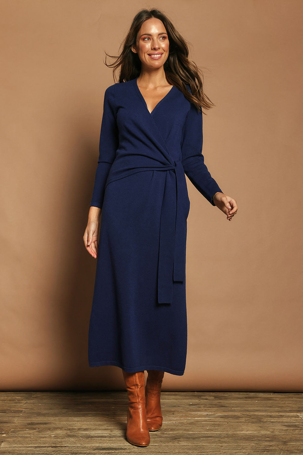 Model Madeline wearing size S of The Tie Waist Faux Wrap Knit Dress in colour Navyblue (Blue), from the front, showing the whole outfit