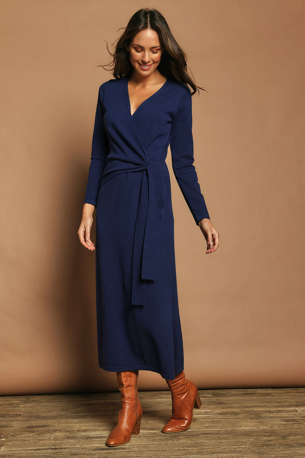 Model Madeline wearing size S of The Tie Waist Faux Wrap Knit Dress in colour Navyblue (Blue), from the front, showing the whole outfit