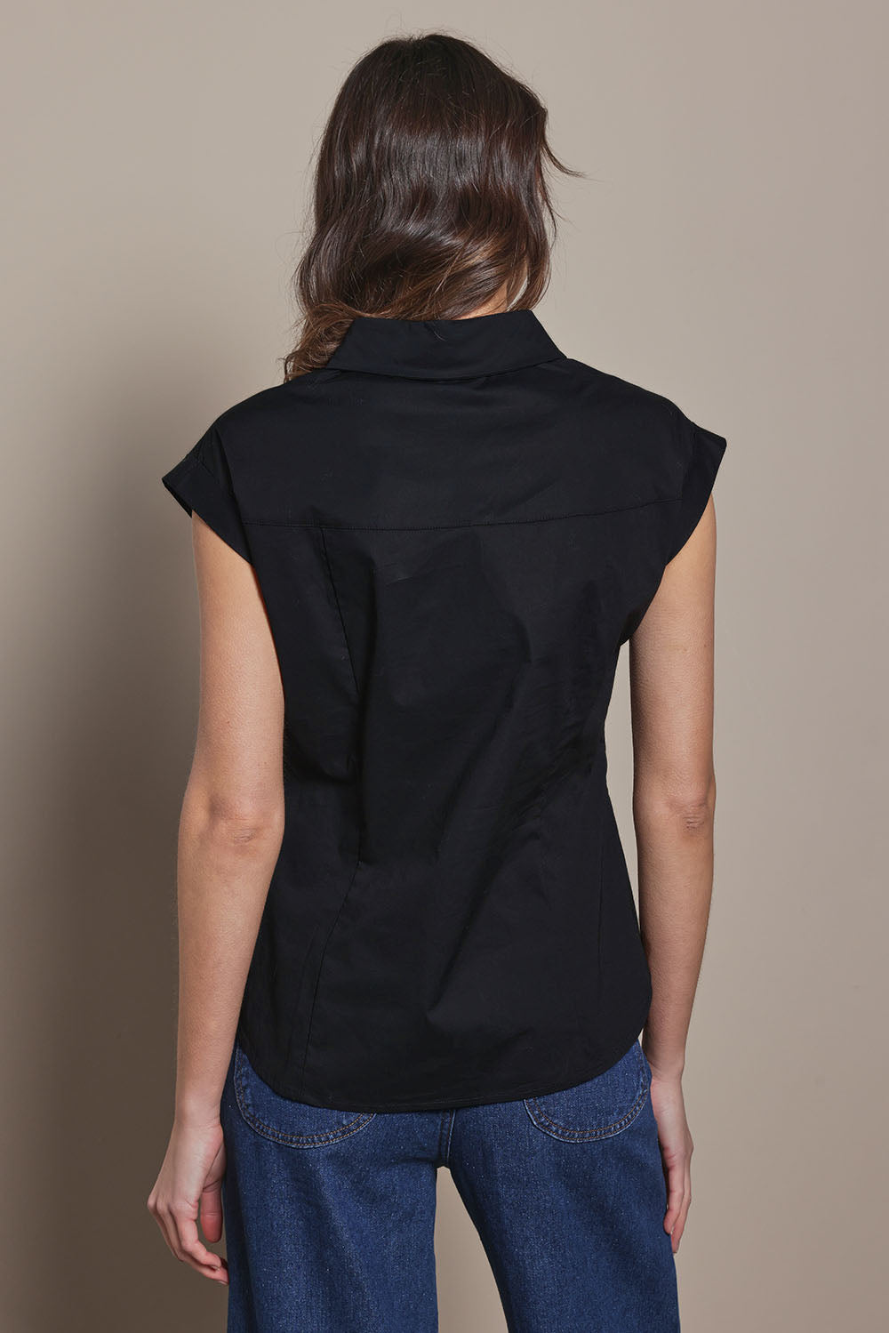 Model Madeline wearing size 10 of The Cap Sleeve Cotton Stretch Shirt in colour Black (Black), from the back