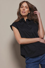 Model Madeline wearing size 10 of The Cap Sleeve Cotton Stretch Shirt in colour Black (Black), from the front, cropped image