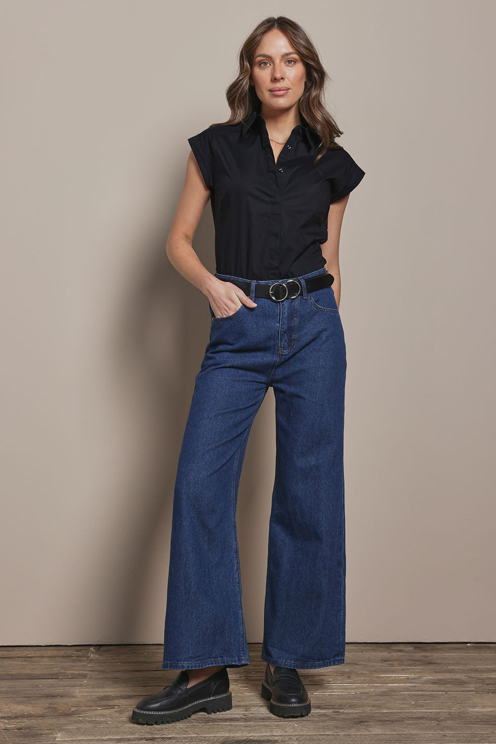 Model Madeline wearing size 10 of The Cap Sleeve Cotton Stretch Shirt in colour Black (Black), from the front, showing the whole outfit