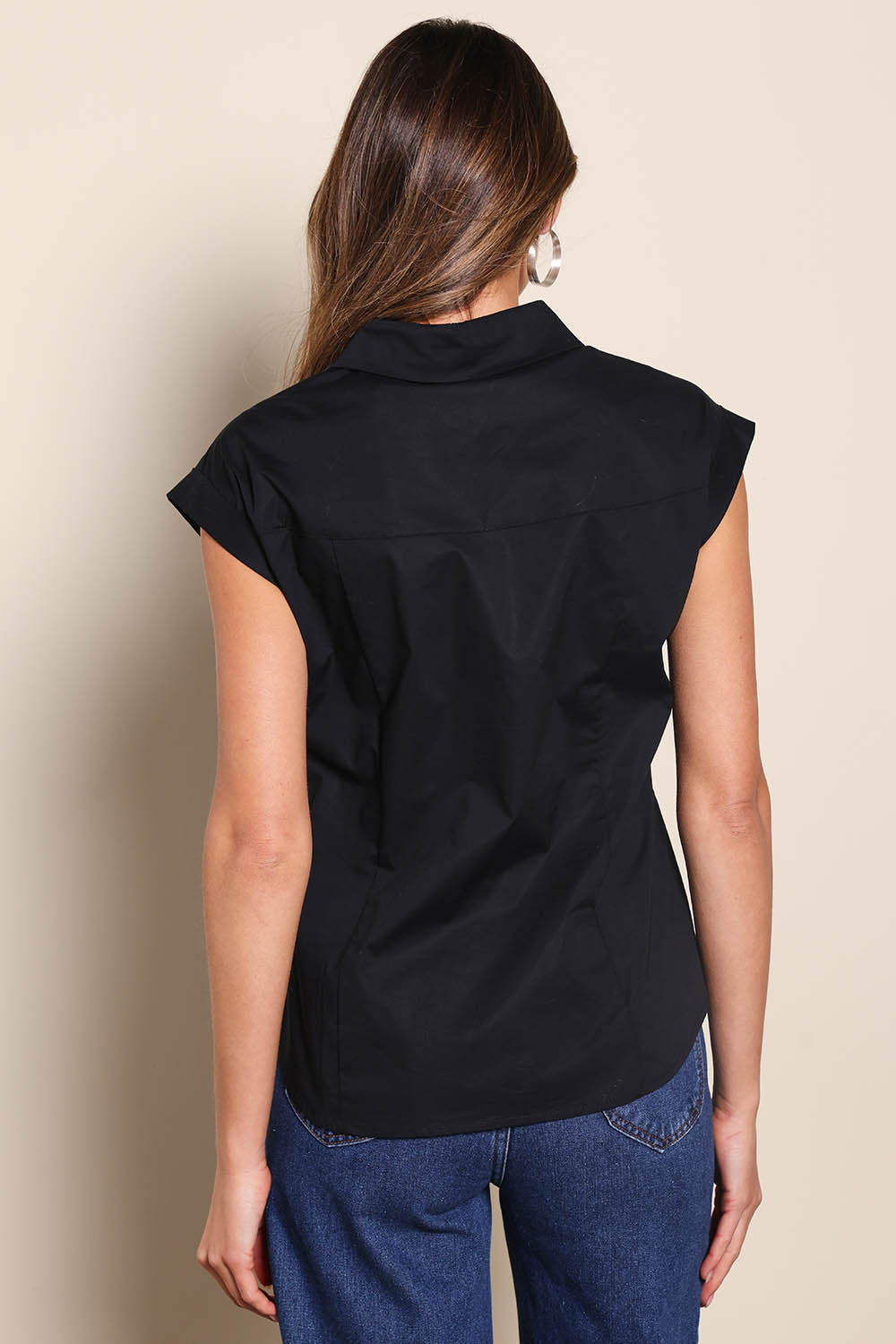 Model Madelinec wearing size 10 of the The Cap Sleeve Cotton Stretch Shirt - Black in colour Black, from the back