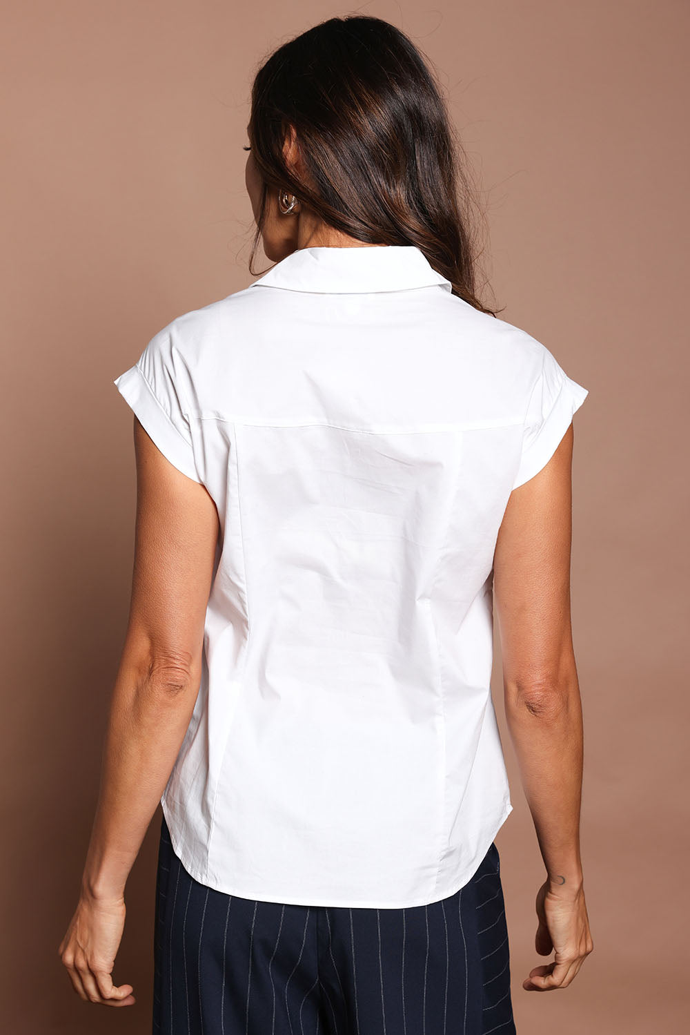 Model Amanda wearing size 10 of The Cap Sleeve Cotton Stretch Shirt in colour White (White), from the back