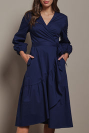 Model Madeline wearing size 10 of The Cotton Wrap Dress With Frill Detail in colour Navyblue (Blue), from the front, cropped image