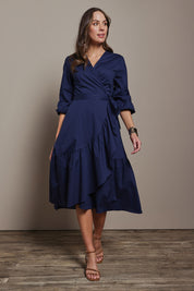Model Madeline wearing size 10 of The Cotton Wrap Dress With Frill Detail in colour Navyblue (Blue), from the front, showing the whole outfit