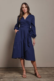 Model Madeline wearing size 10 of The Cotton Wrap Dress With Frill Detail in colour Navyblue (Blue), from the front, showing the whole outfit