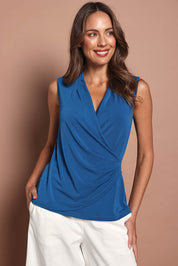 Model Madeline wearing size 10 of The Sleeveless Crossover Top in colour Tealblue (Blue), from the front, cropped image