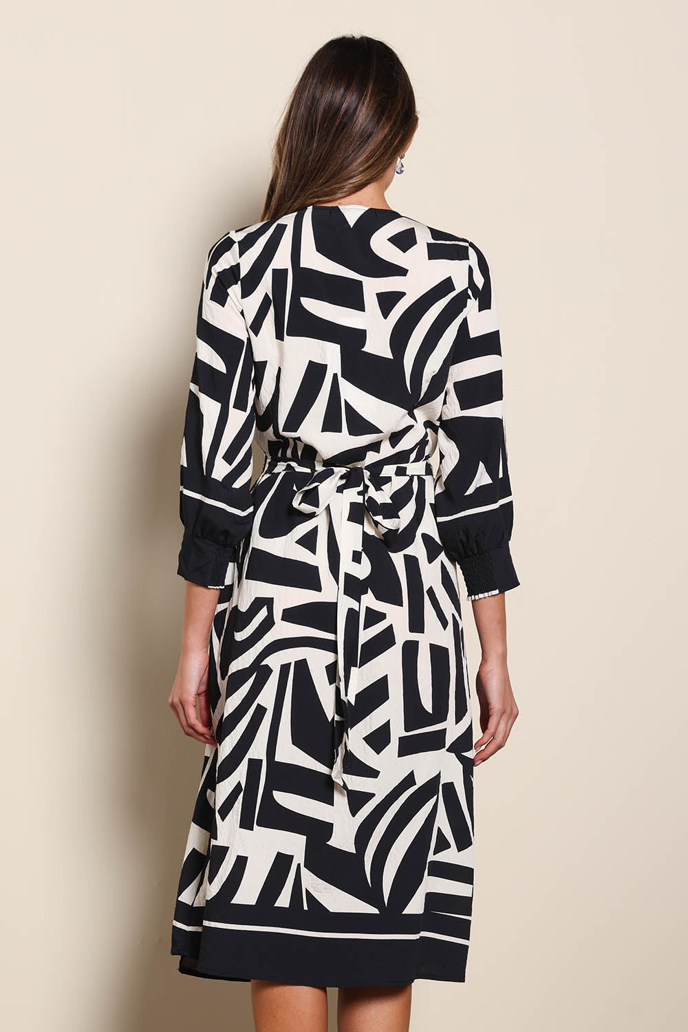 Model Madelinec wearing size 10 of the The Printed Wrap Dress - Blackabstract in colour Blackabstract, from the back