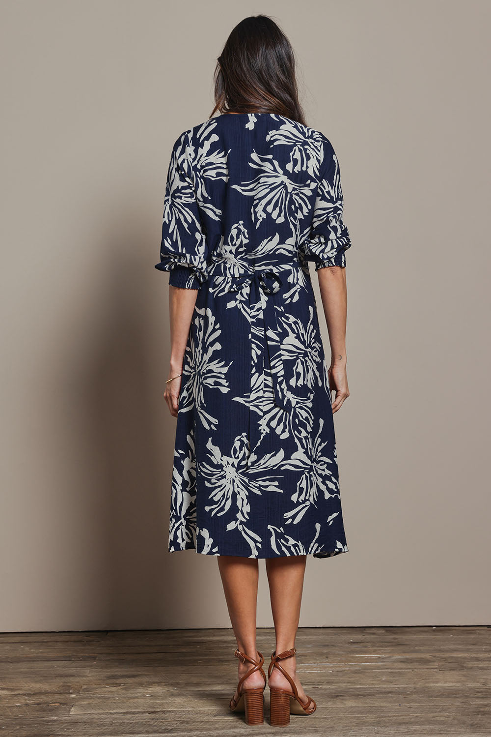 Model Amanda wearing size 10 of The Printed Wrap Dress in colour Navyfleur (Blue), from the back