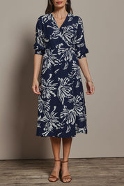 Model Amanda wearing size 10 of The Printed Wrap Dress in colour Navyfleur (Blue), from the front, cropped image