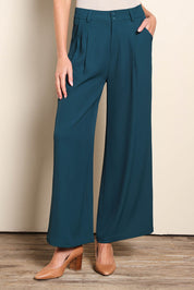 Model Madelinec wearing size 10 of the The Soft Suiting Pant – Darkteal in colour Darkteal, in a cropped view